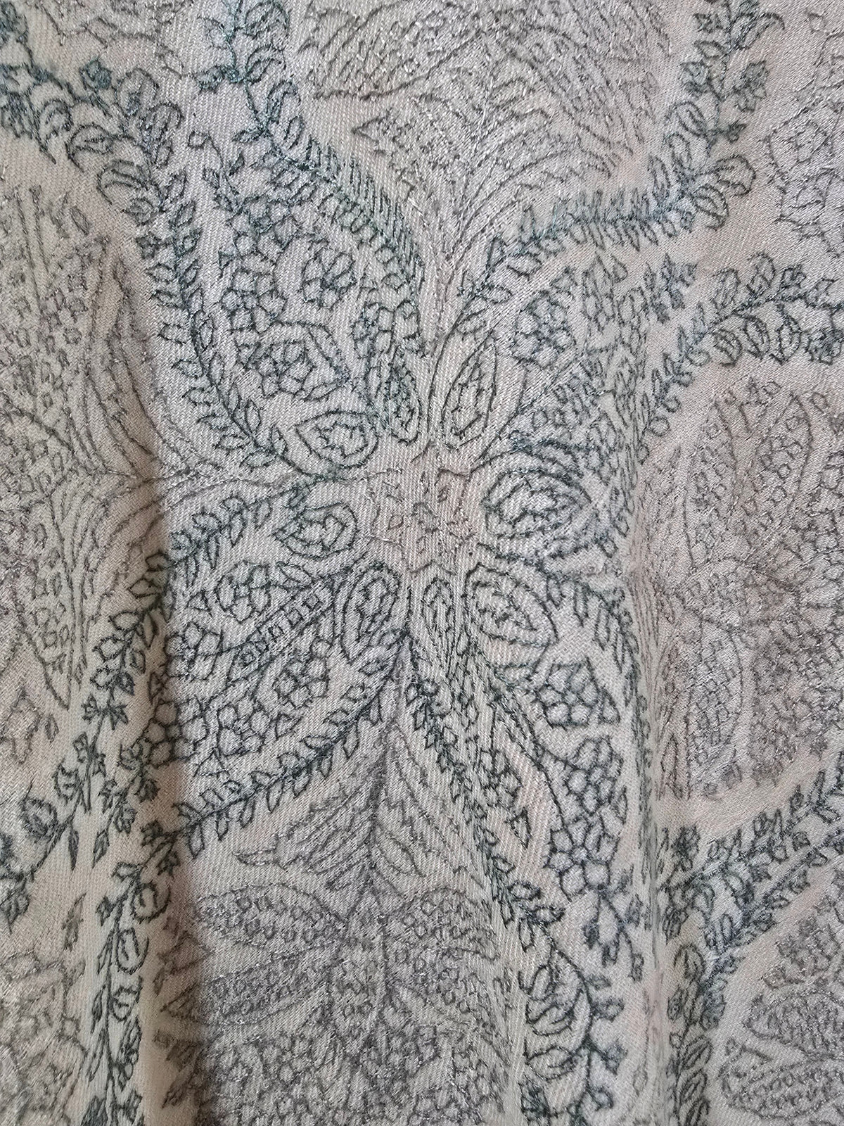 Fine Sozni embroidery on ivory Pashmina, with curling floral motifs and leafy outlines between larger patterned panels