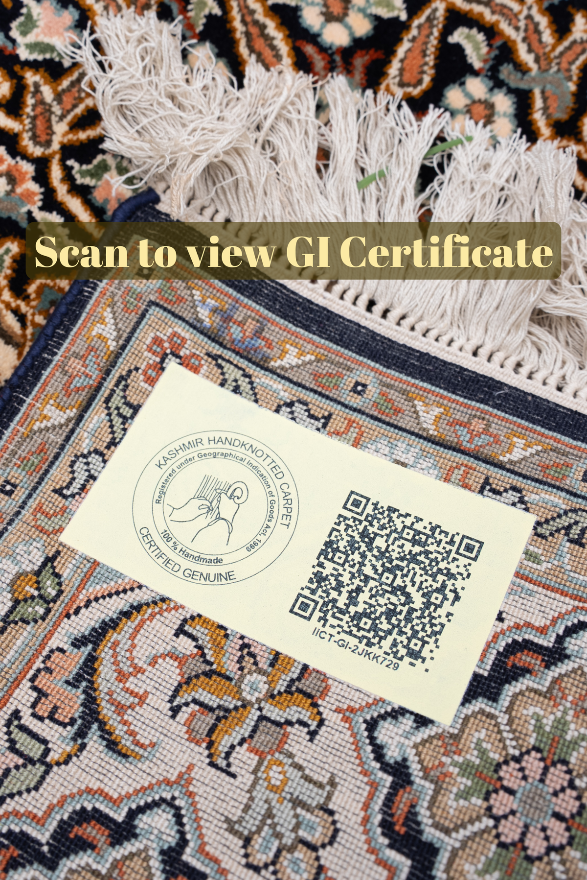 QR-code label on a folded dark floral carpet corner beside ivory fringe, with the text Scan to view GI Certificate