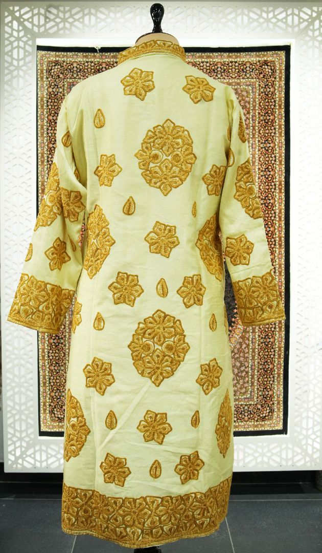 Back of the ivory jacket with scattered gold Aari flower medallions, small leaf motifs and dense embroidered cuff and hem borders.