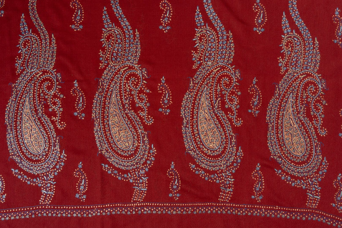Deep red shawl end with large multicoloured Sozni paisleys and smaller motifs above a narrow floral border