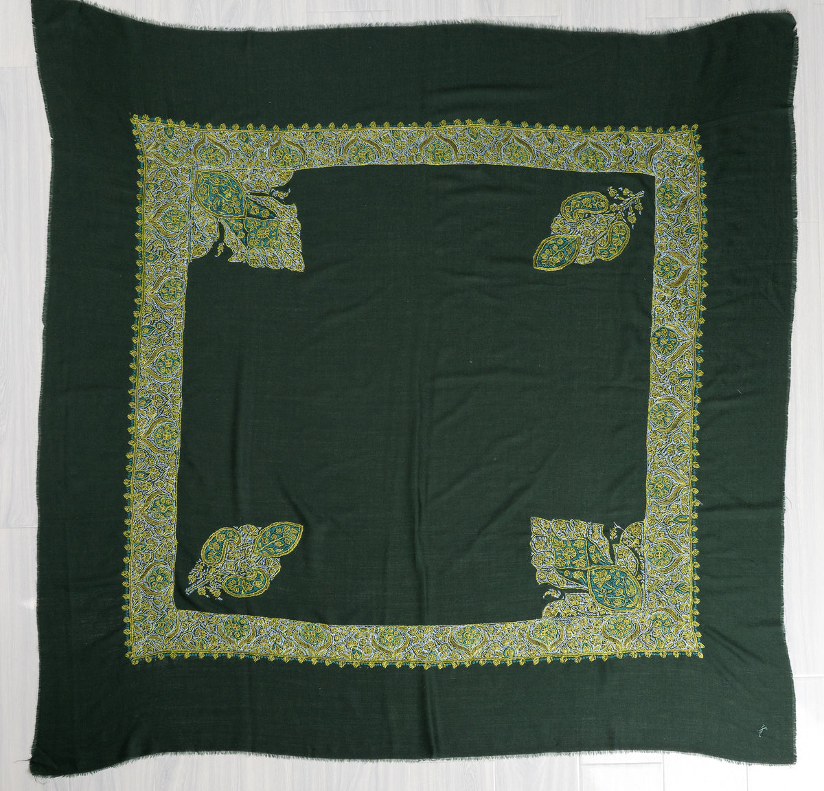 Square emerald green rumal spread flat, with a plain centre, broad embroidered border and four corner motifs