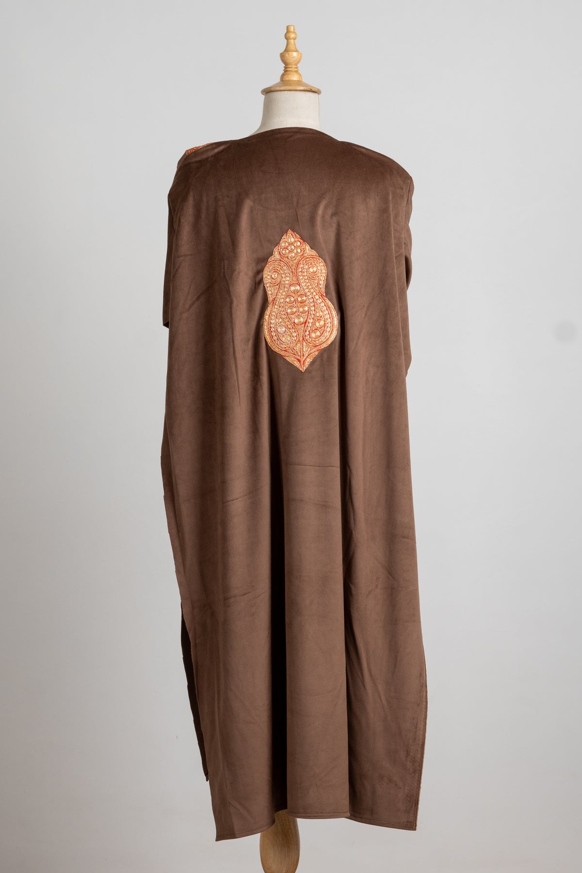 Full back of the brown velvet pheran with a single large gold-toned embroidered motif at the centre.
