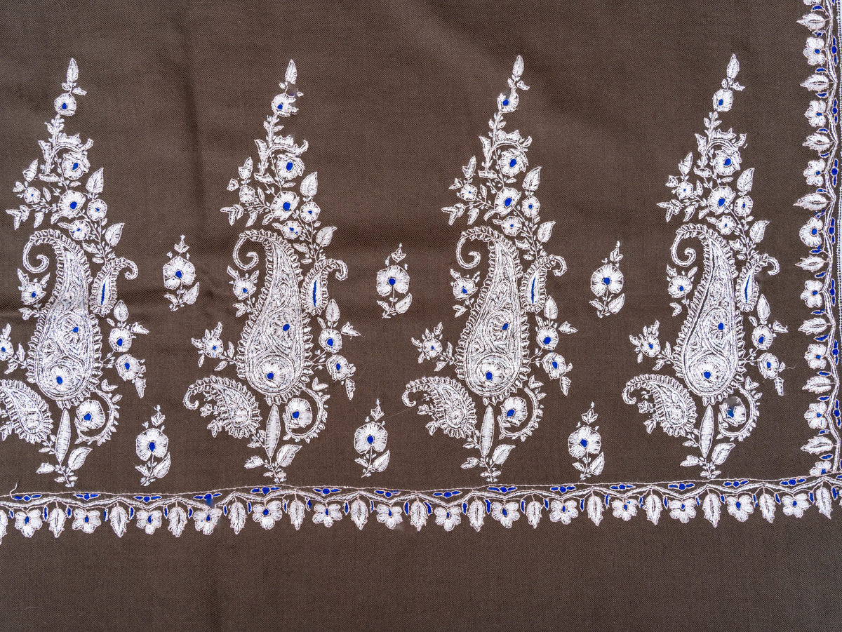Corner detail of the mocha-brown shawl, where ivory paisley sprays meet the narrow floral side border