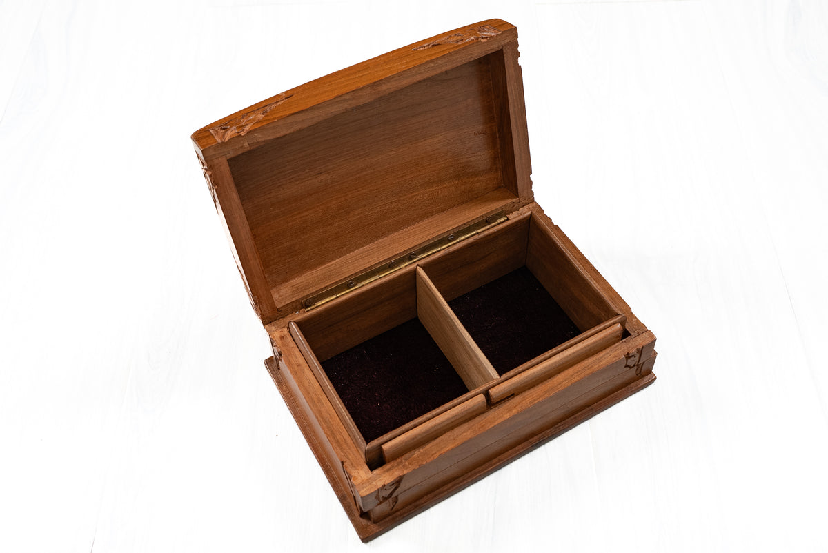 Angled view of an open walnut wood box with two dark-lined storage compartments and visible lid hinges
