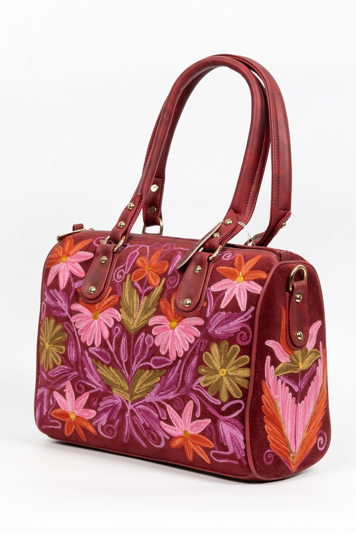 Angled front view of the maroon Aari handbag, showing its embroidered flower panel, patterned side and upright handles