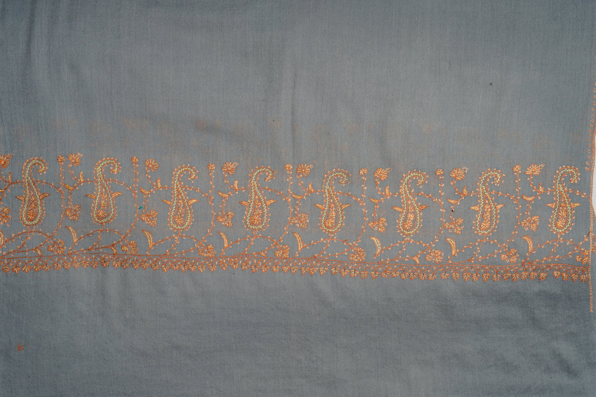 Grey stole laid flat, showing a row of fine orange paisleys and branching floral stems above a narrow border.
