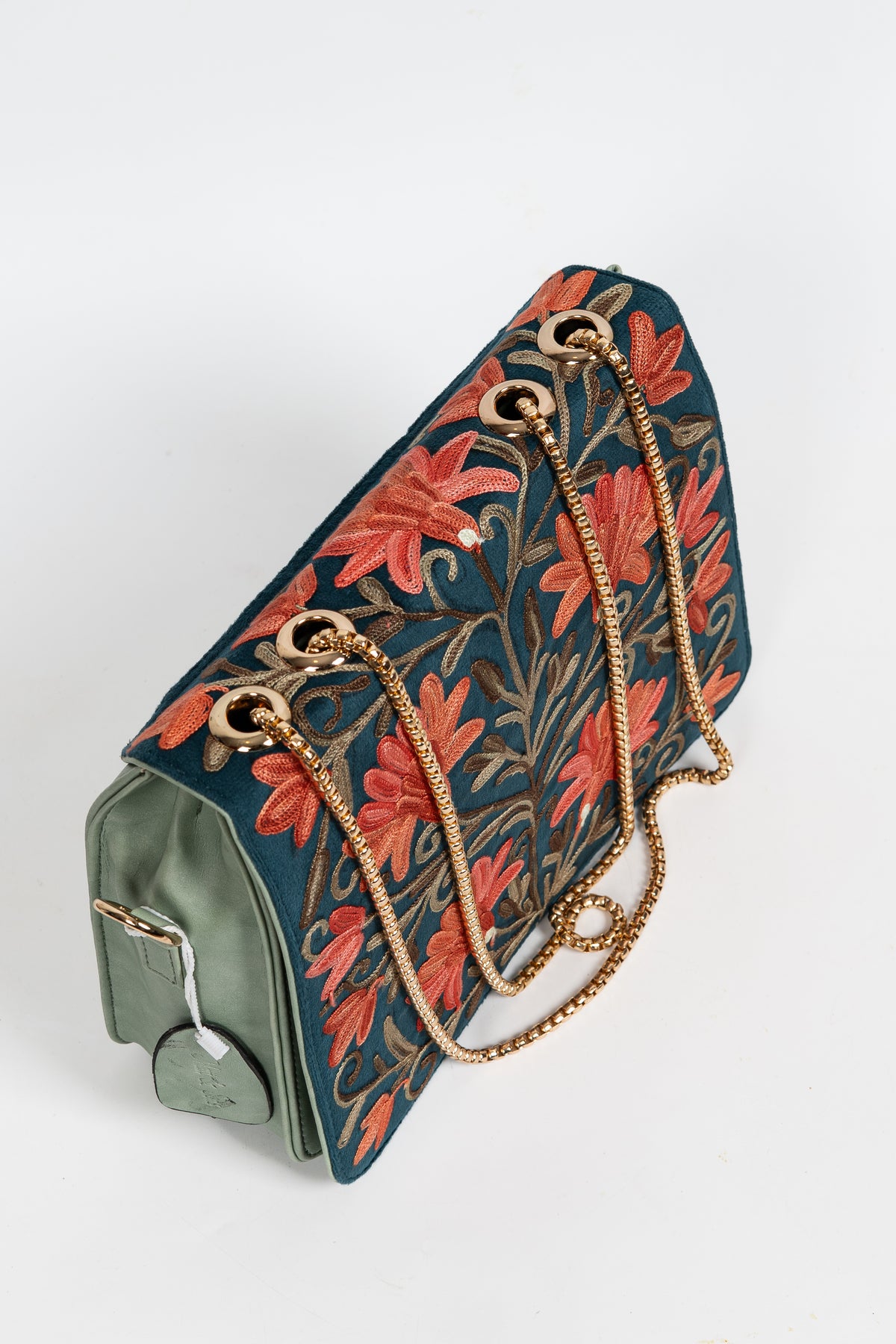 Angled top view of a teal Aari floral bag with gold-toned chain straps and pale green side panels