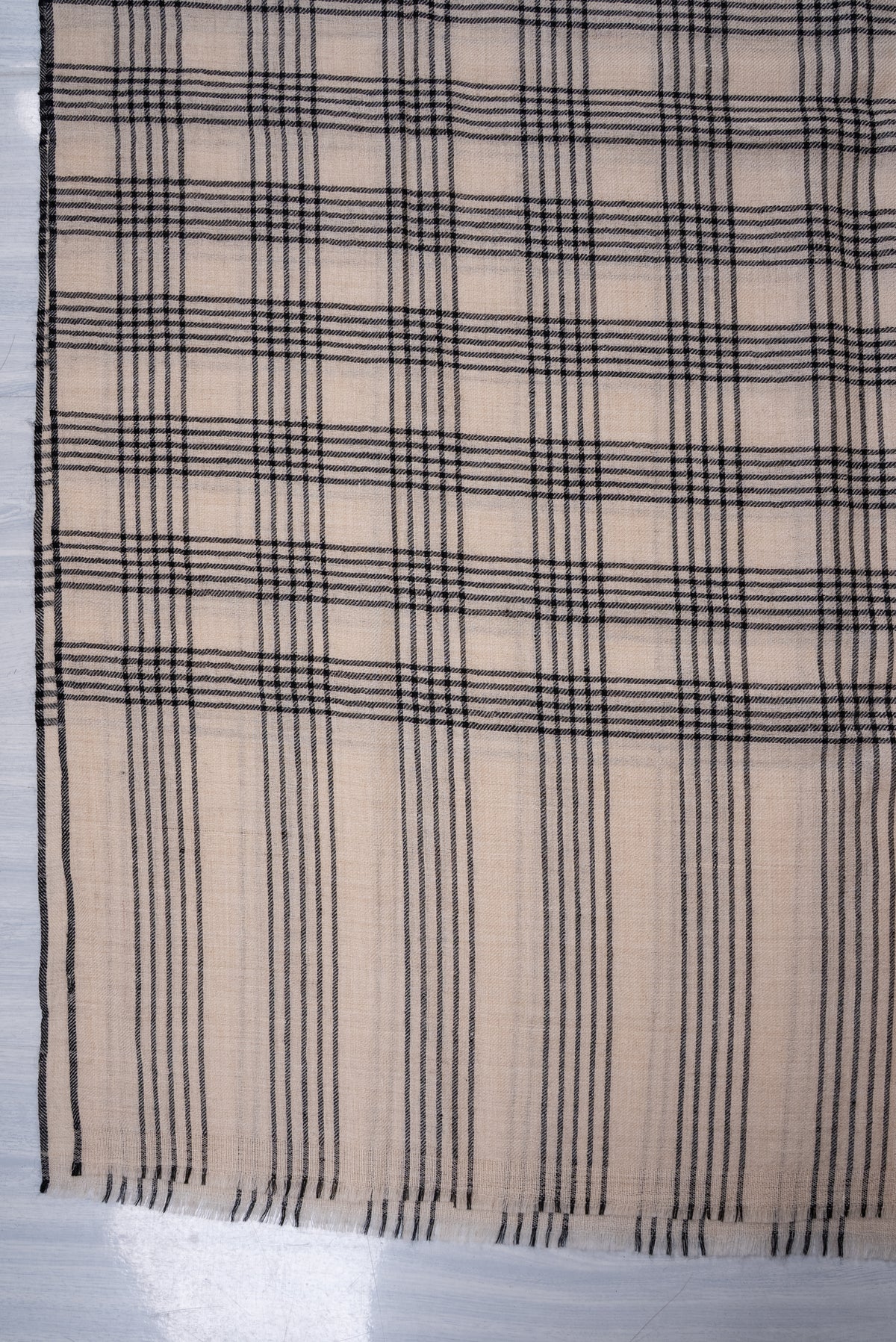 Ivory Pashmina scarf end detail showing black plaid checks changing to fine vertical stripes above short fringe