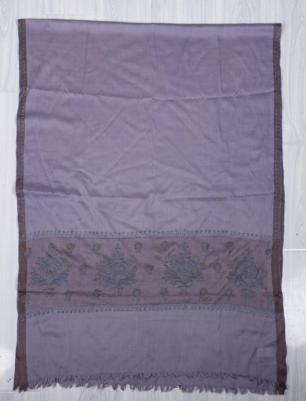 Lavender scarf laid flat lengthwise, with narrow embroidered sides and blue-and-olive floral bouquets in a mauve band near the fringed end.
