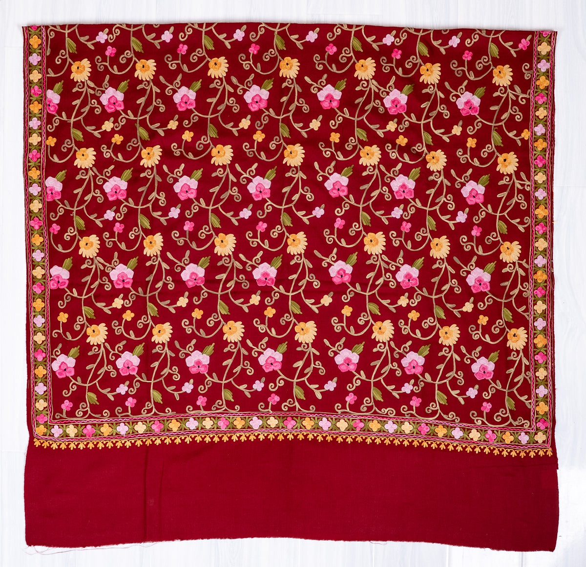 Maroon shawl spread flat, with pink and golden floral Aari vines, narrow matching borders and a wide plain end