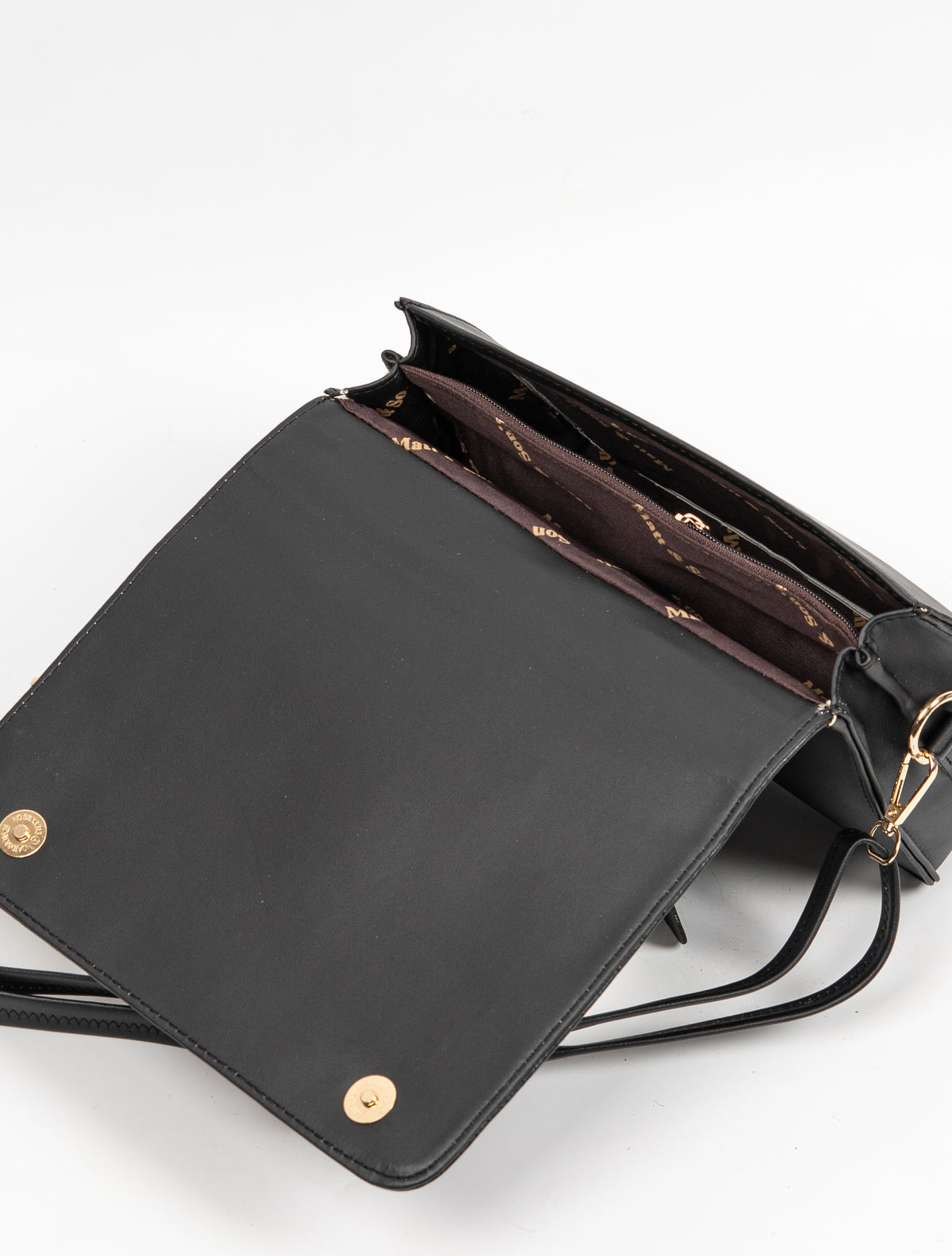 Black handbag with its front flap open, showing gold-toned magnetic fasteners and a divided brown-lined interior