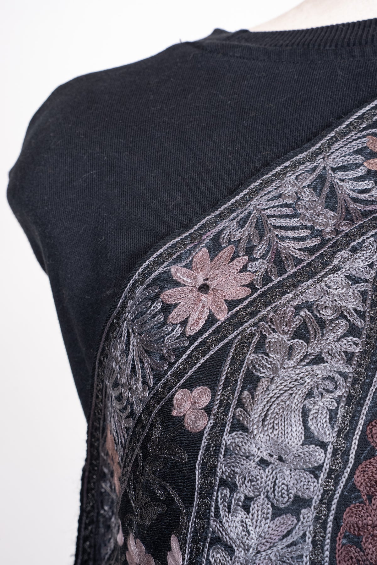 Shoulder detail of black shawl with silver leafy Aari embroidery and muted-rose flowers along the border