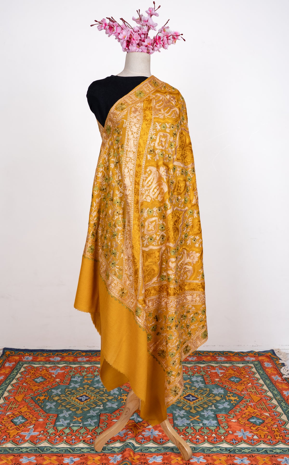Full view of the mustard shawl on a mannequin, with pale Aari medallion panels and a broad plain golden end