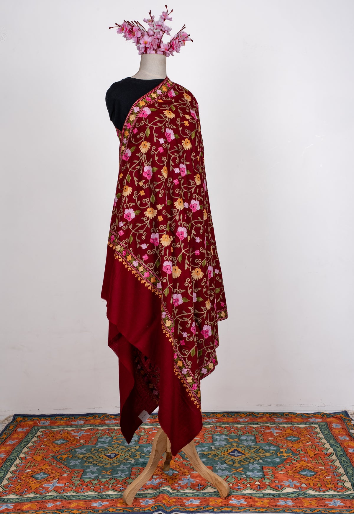 Full-length maroon shawl draped over one shoulder, with pink and golden floral vines, patterned borders and a plain end