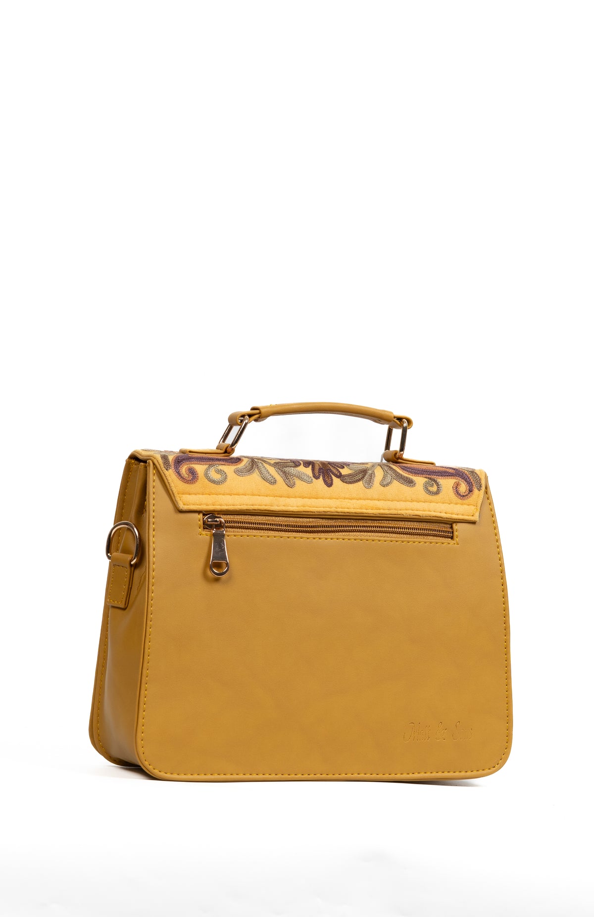 Angled rear view of the mustard handbag with its plain back panel, zipper, short handle and side attachment ring.