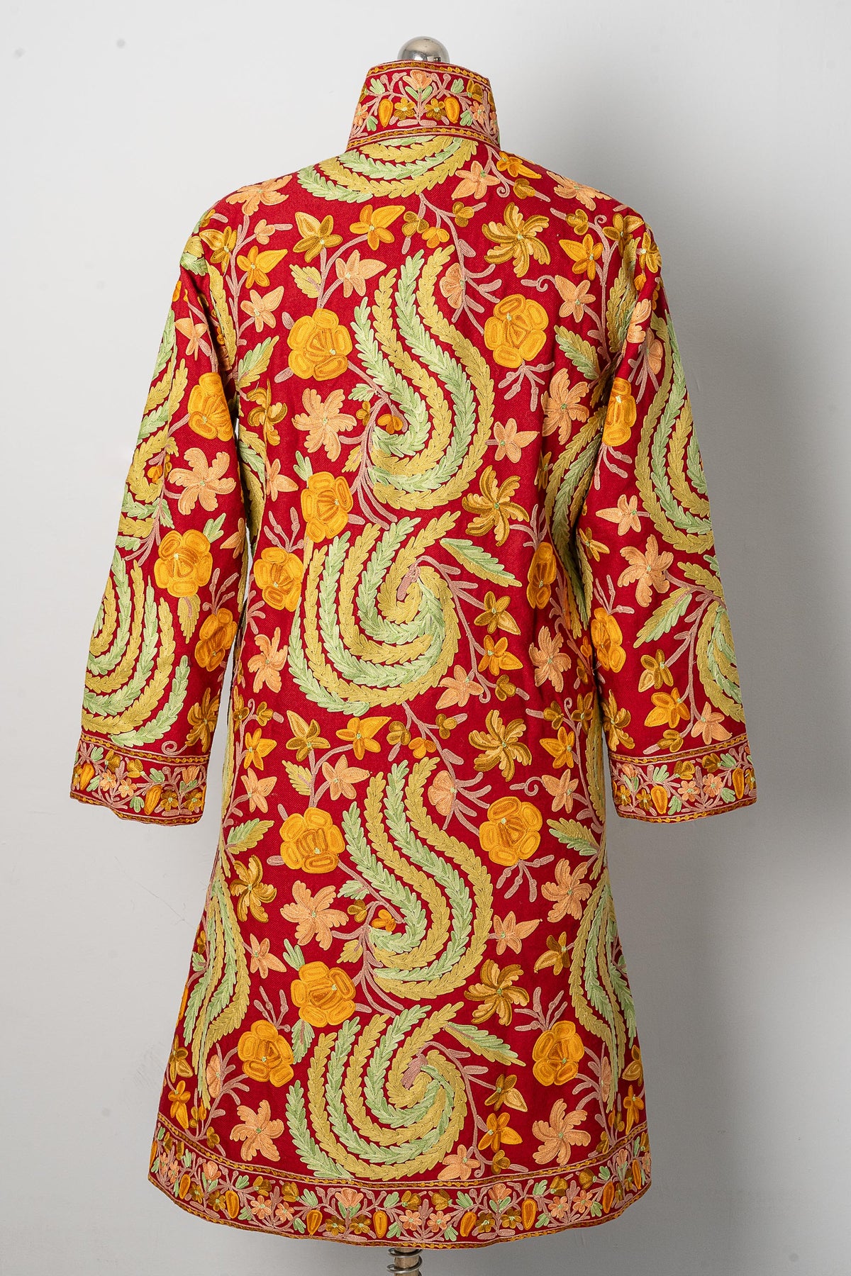 Back view of the maroon long jacket, with large pale green leafy swirls among yellow and cream flowers