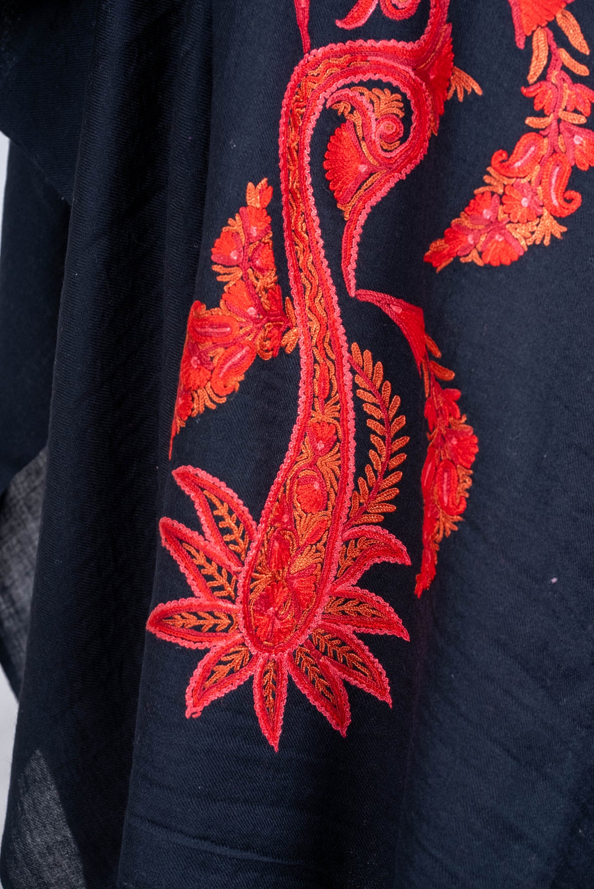 Detail of the black cape's large red-orange paisley ending in a pointed flower motif