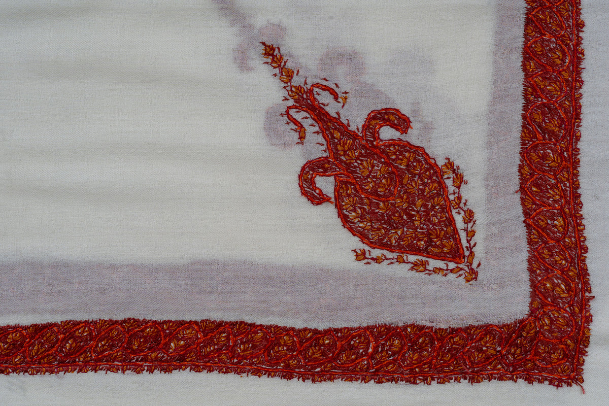 Ivory rumal corner with an elongated red-orange Sozni motif inside narrow floral borders
