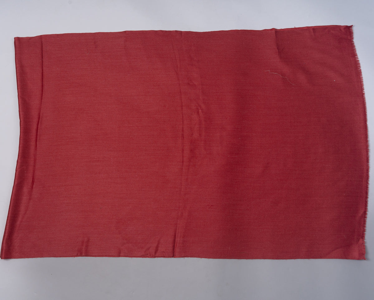 Crimson stole laid flat across a pale surface, showing its unpatterned weave and simple edges