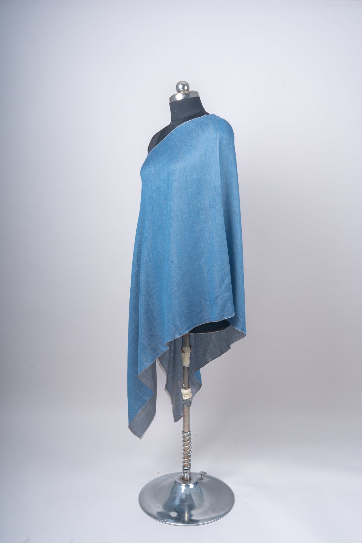 Angled full view of the blue stole with the steel-grey reverse visible beneath its hanging edge.