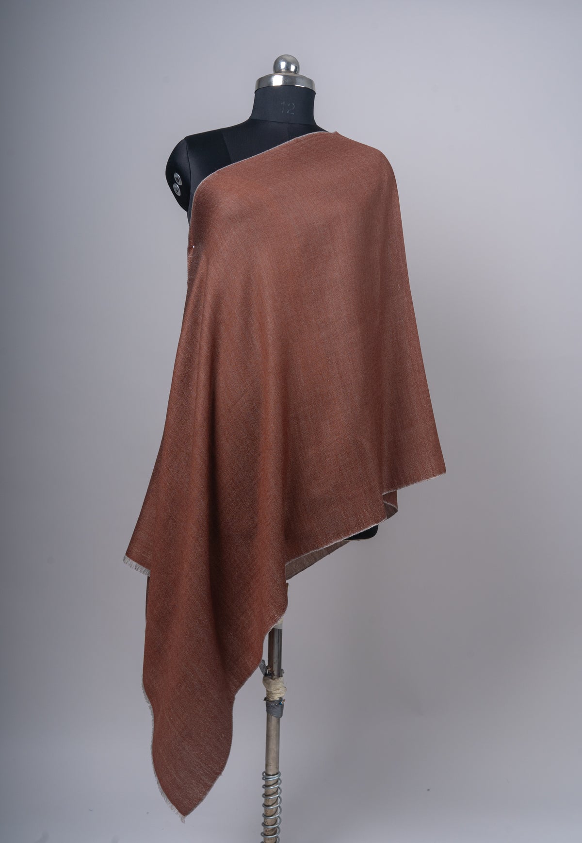 Front view of a plain cinnamon Merino wool stole draped over a mannequin, with a narrow sand-grey reverse edge