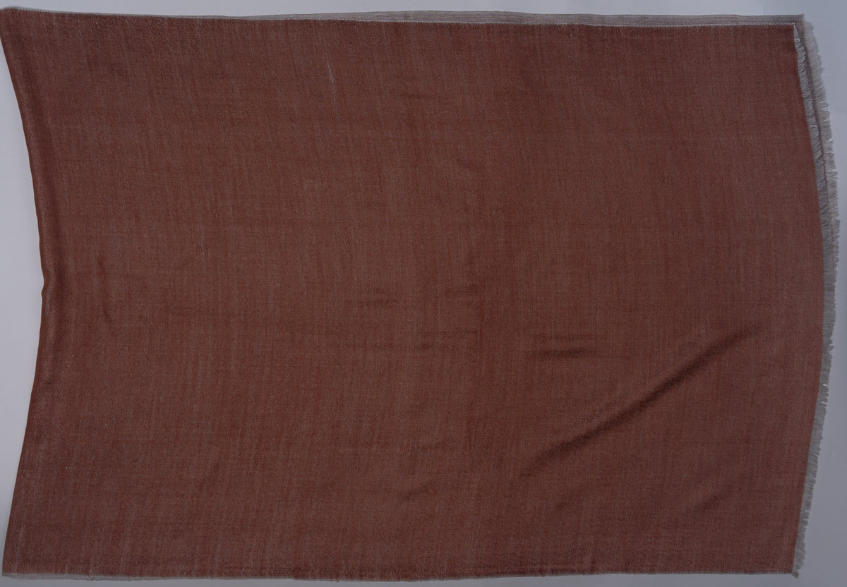 Cinnamon side of a reversible Merino wool stole spread flat, showing a plain rectangular panel edged with sand-grey
