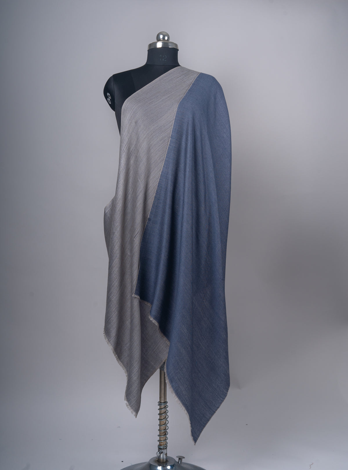 Reversible stole arranged on a mannequin to display the slate-grey and blue faces side by side.