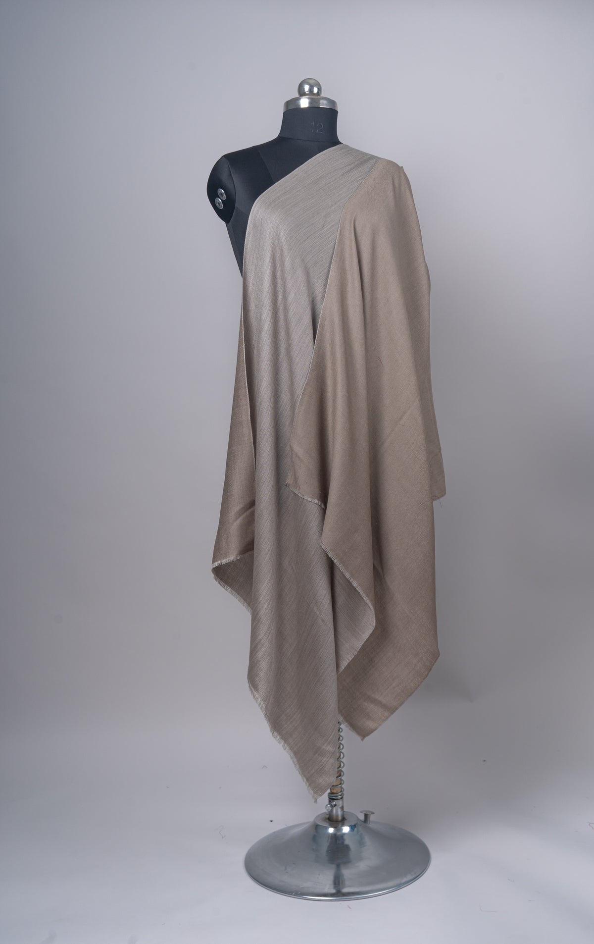 Reversible taupe and sand Merino wool stole draped in long layers down the front of a mannequin