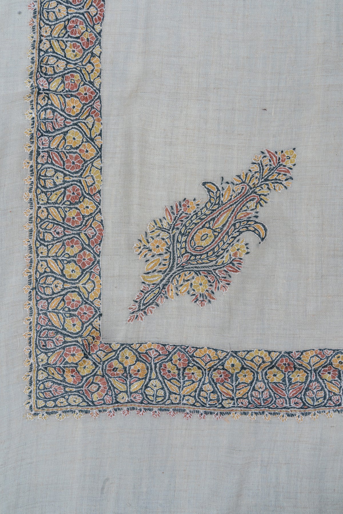 Ivory rumal corner with a blue, coral and yellow floral border and a matching paisley motif
