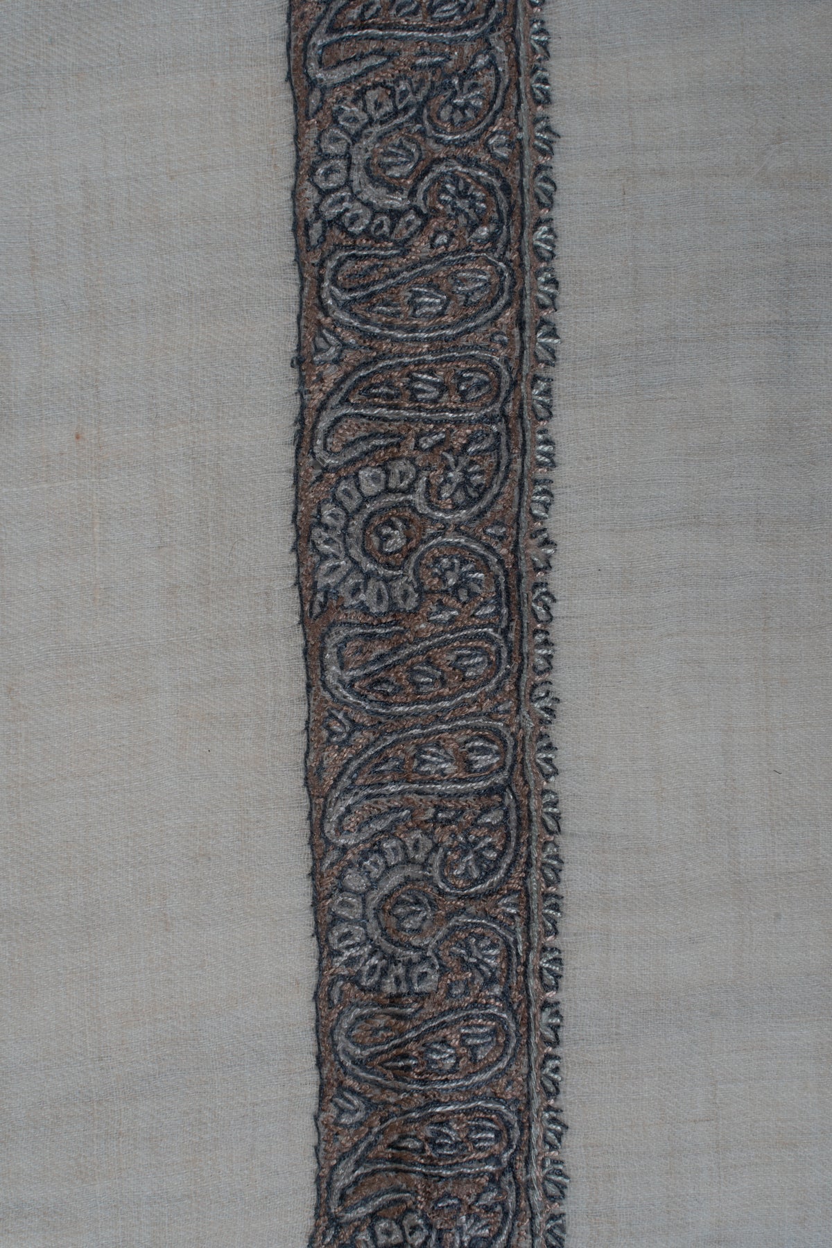 Close-up of dense grey-blue paisleys and fine leaf edging in the cream rumal's border