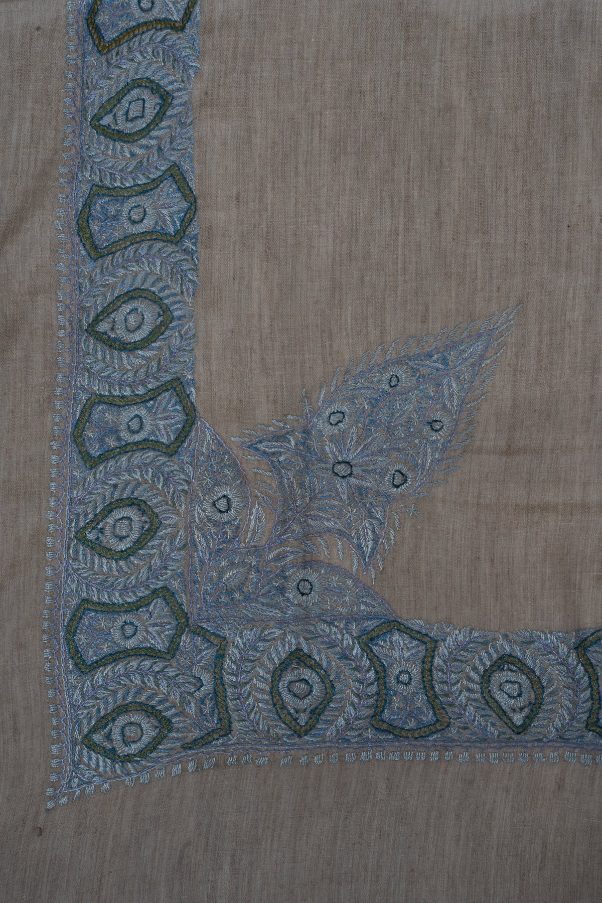 Rumal corner with a broad blue geometric border and a large pointed floral design