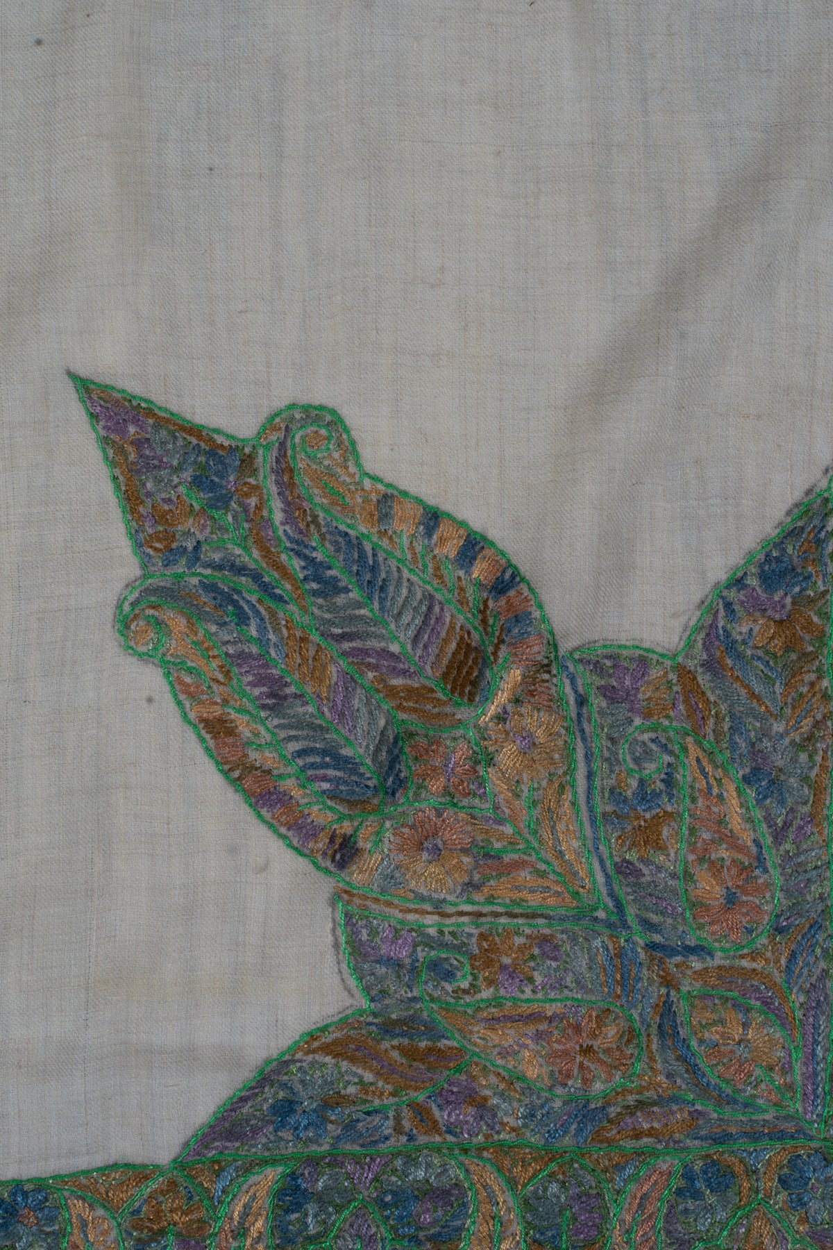 Close-up of the large leaf-shaped corner motif with green outlines and fine blue, gold and lavender details