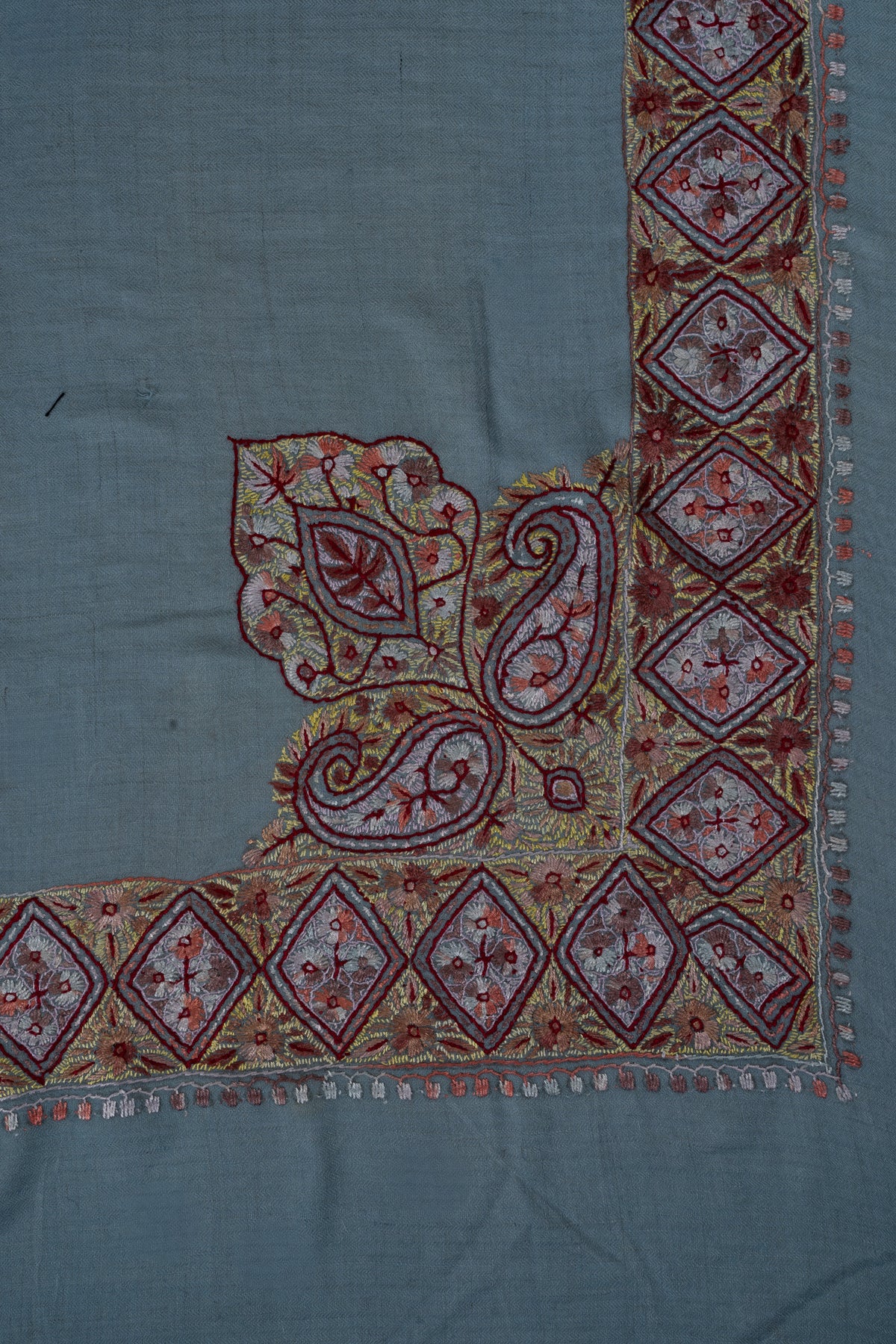 Large Sozni paisleys and a leaf motif rise from garnet and gold diamond borders on a sky-blue cashmere rumal.