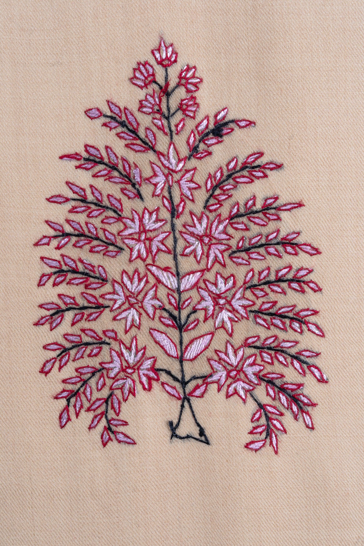 Close-up of a rose-pink flowering tree motif with dark stems embroidered on sand-beige fabric