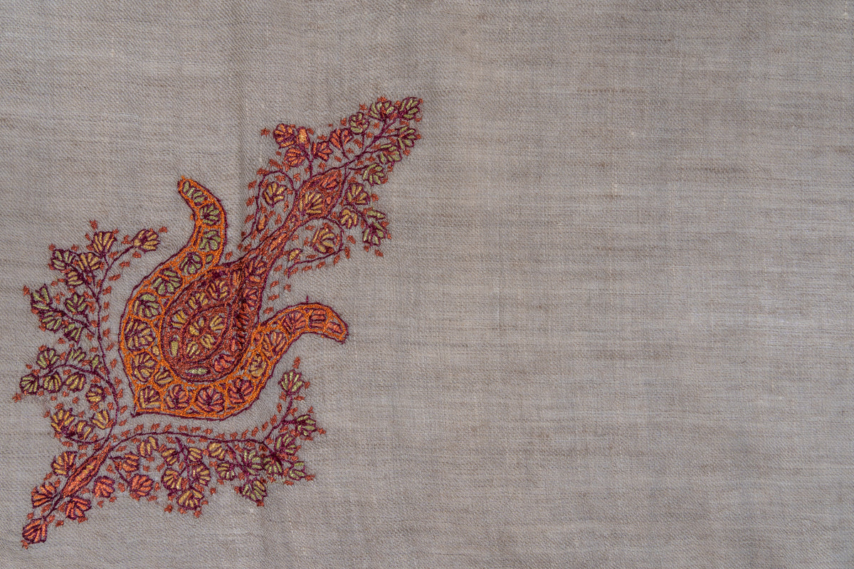 Saffron and crimson Sozni paisley surrounded by small leafy sprigs on taupe cashmere