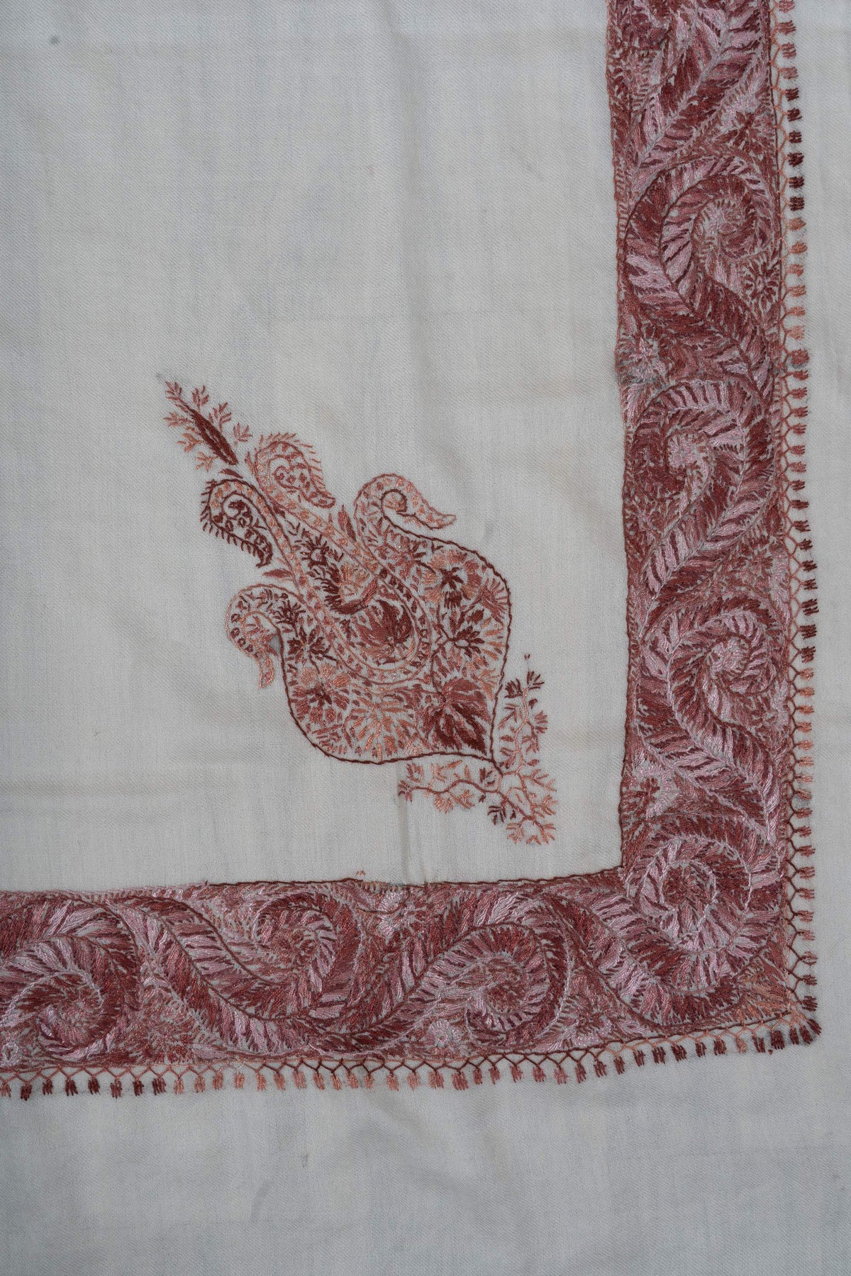 Ivory rumal corner with a smaller dusty-rose floral motif inside the broad paisley border