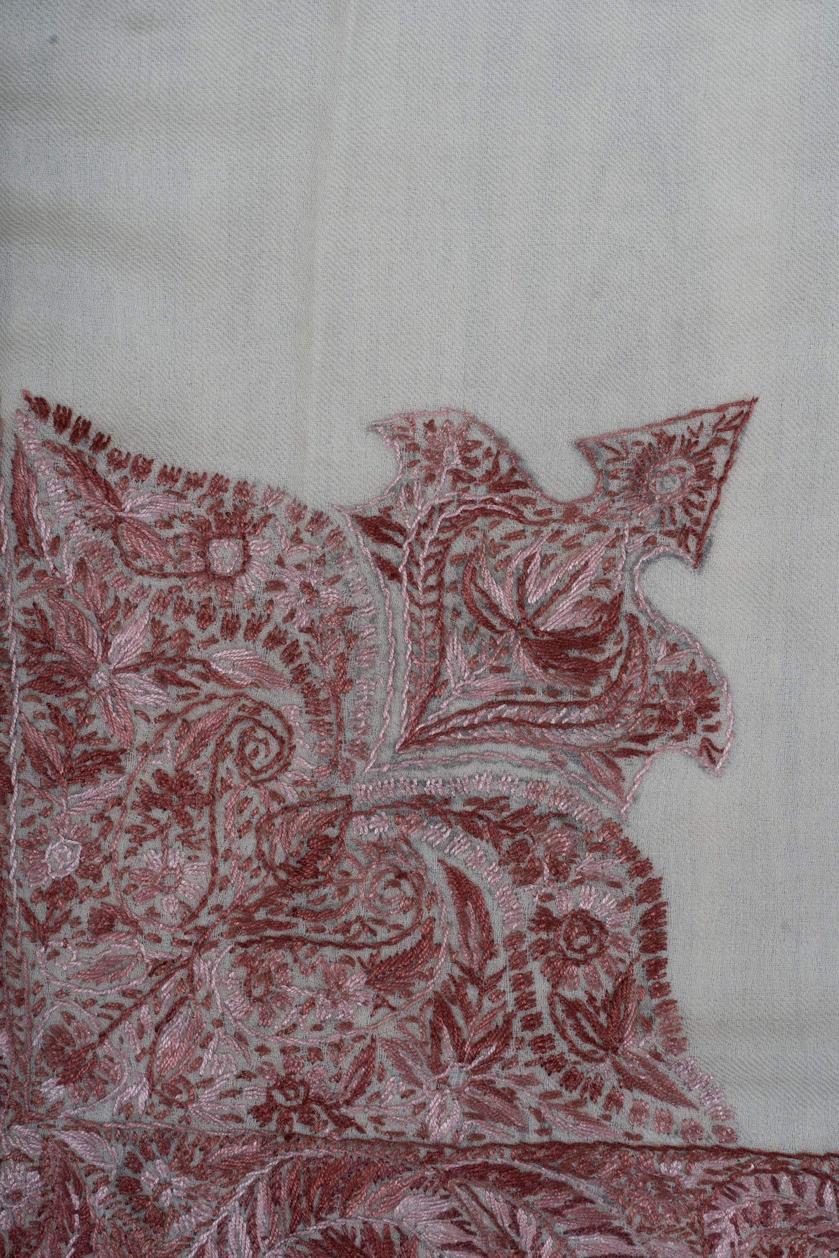 Close-up of the rumal's large corner panel with dusty-rose paisleys and a pointed floral extension