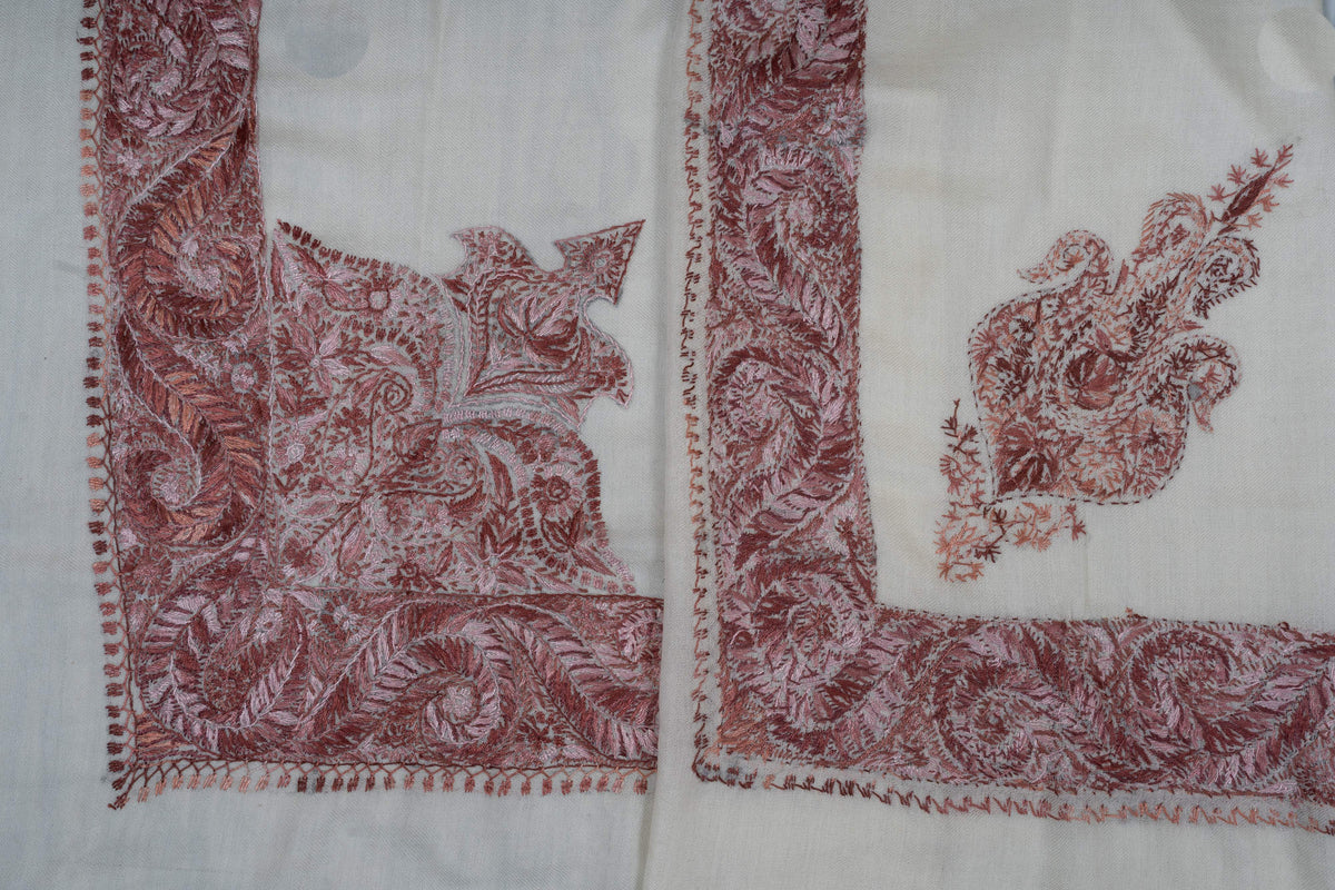 Overlapping ivory rumal corners showing the large paisley panel beside a smaller floral motif