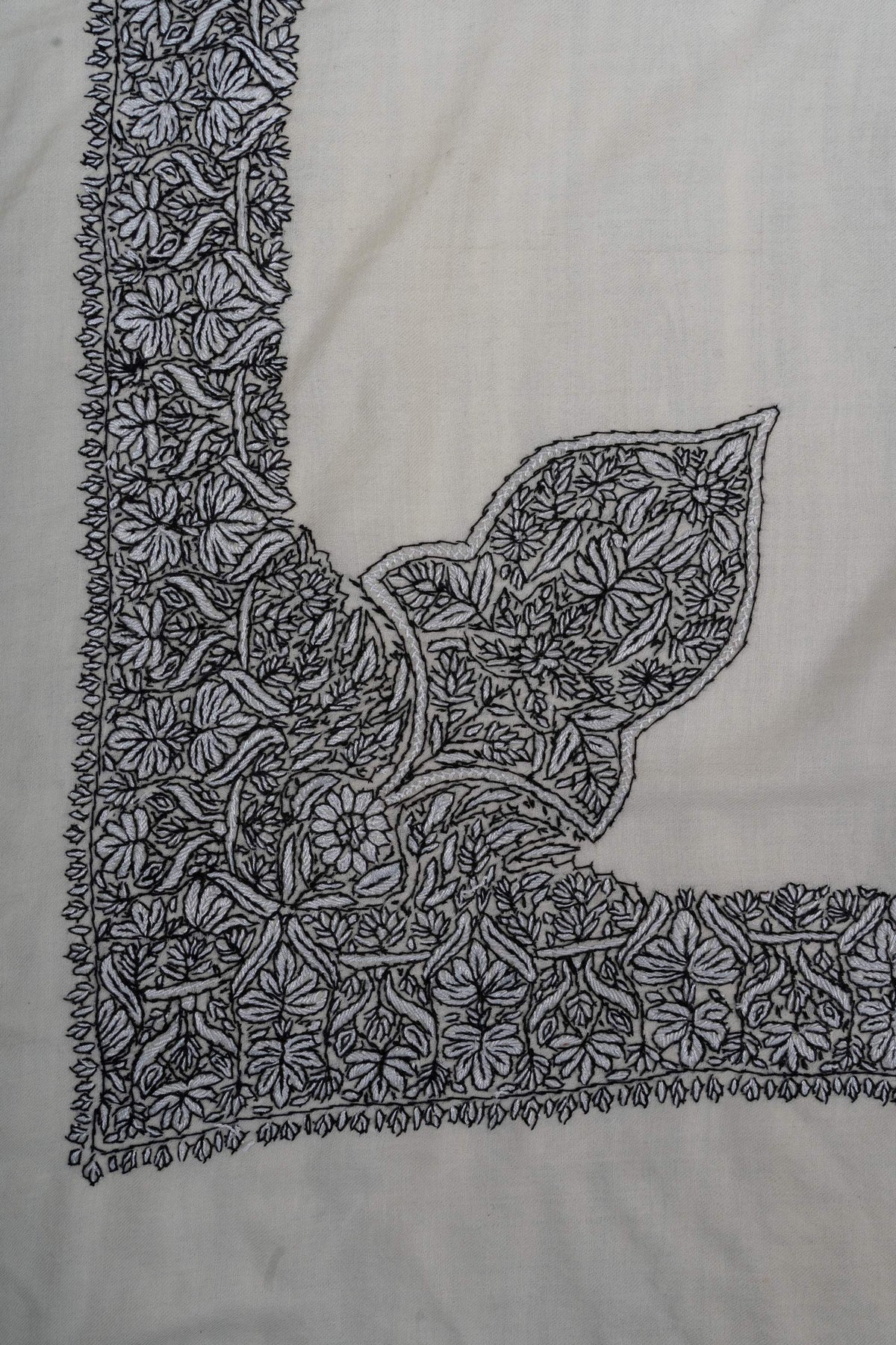 Ivory rumal corner with a large leaf-shaped motif joined to a dense black Sozni floral border