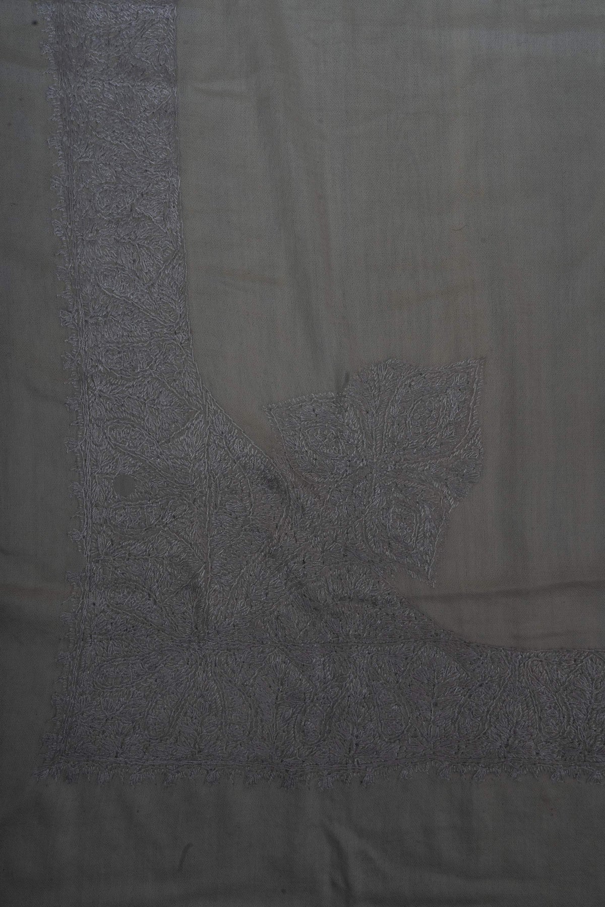 Dense silver-grey Sozni flowers and leaves fill one corner of an ivory Merino wool rumal and join its broad borders.
