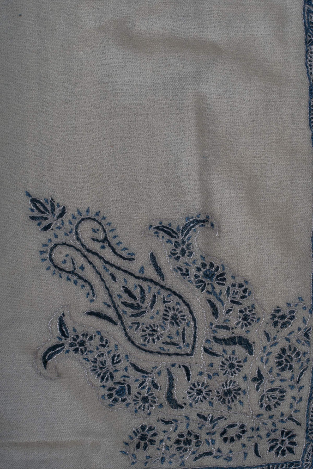 Close-up of the indigo paisley and floral corner motif on the ivory rumal.