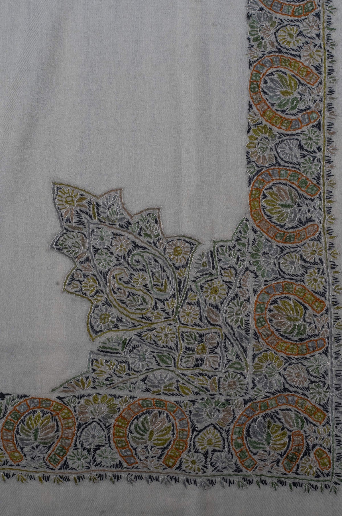 Ivory rumal corner with a large pointed floral motif joined to a broad olive, gold and charcoal Sozni border
