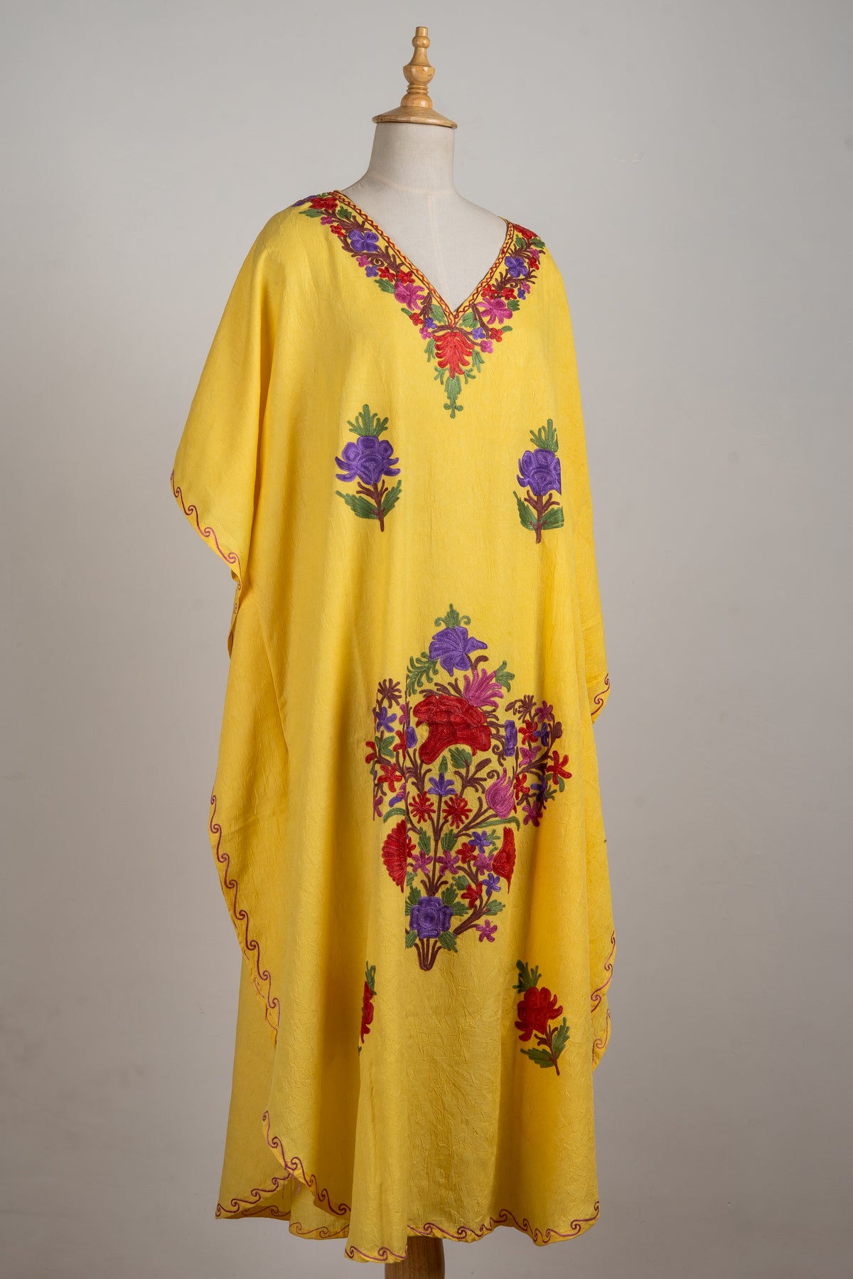 Angled full-length yellow kaftan with an embroidered V-neck, red and purple Aari flower motifs and narrow scrolling edging