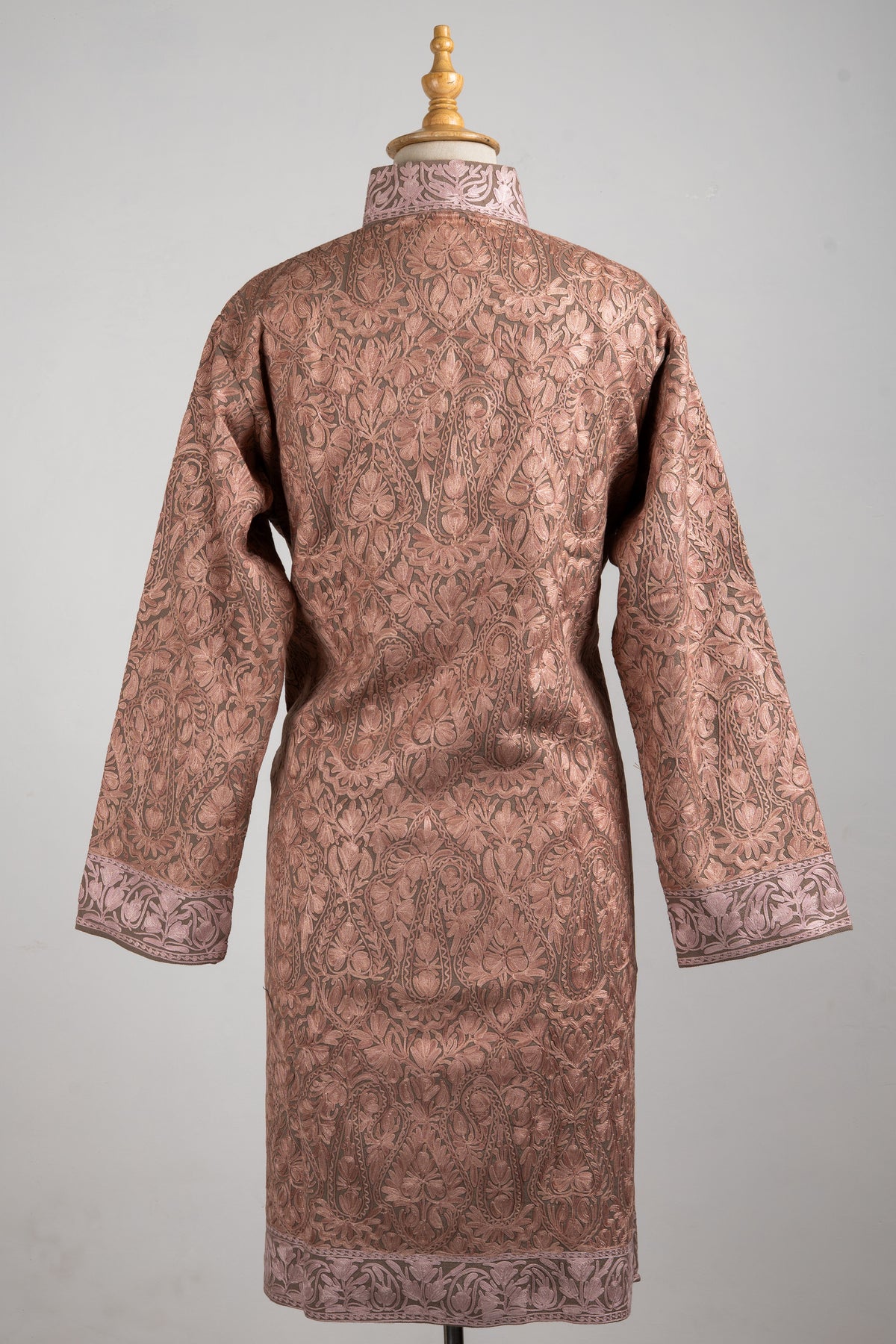 Back view of the rosewood jacket with sleeves spread slightly, showing all-over floral embroidery and pale patterned borders