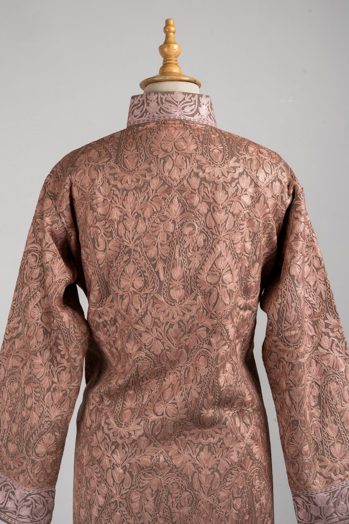 Upper back detail of the dusty-rose jacket, with dense pale floral vines across the shoulders and an embroidered stand collar