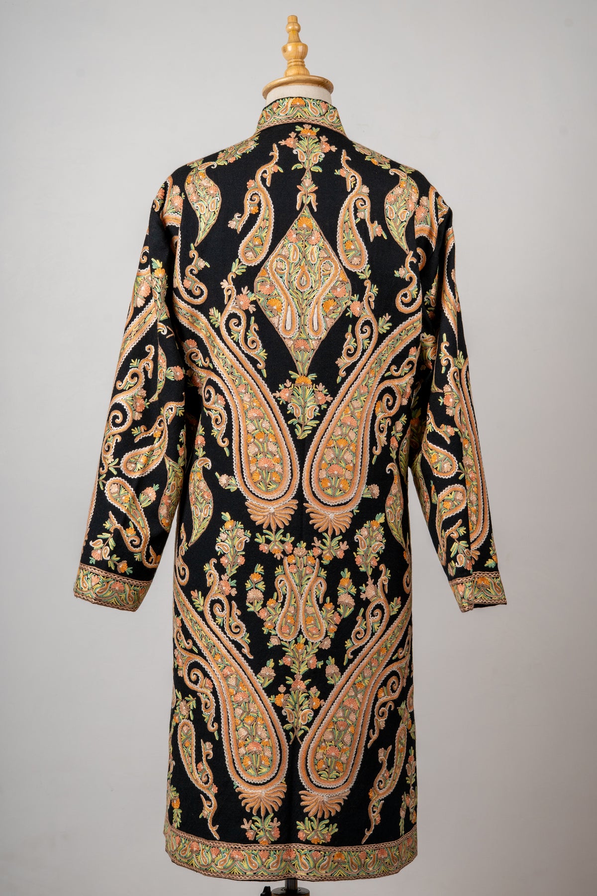 Back of the black wool jacket, with symmetrical peach-and-gold paisleys, diamond-shaped floral motifs and embroidered hem and cuffs