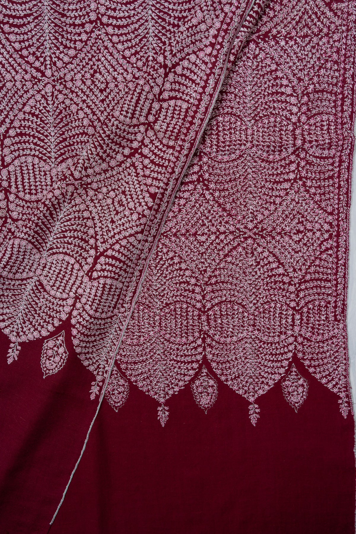 Folded corner of the wine Pashmina shawl showing both sides of the dense circular Sozni pattern and scalloped embroidery