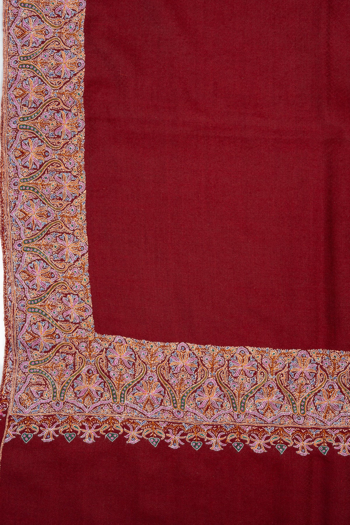Crimson shawl corner with multicoloured Sozni floral border panels above a plain end