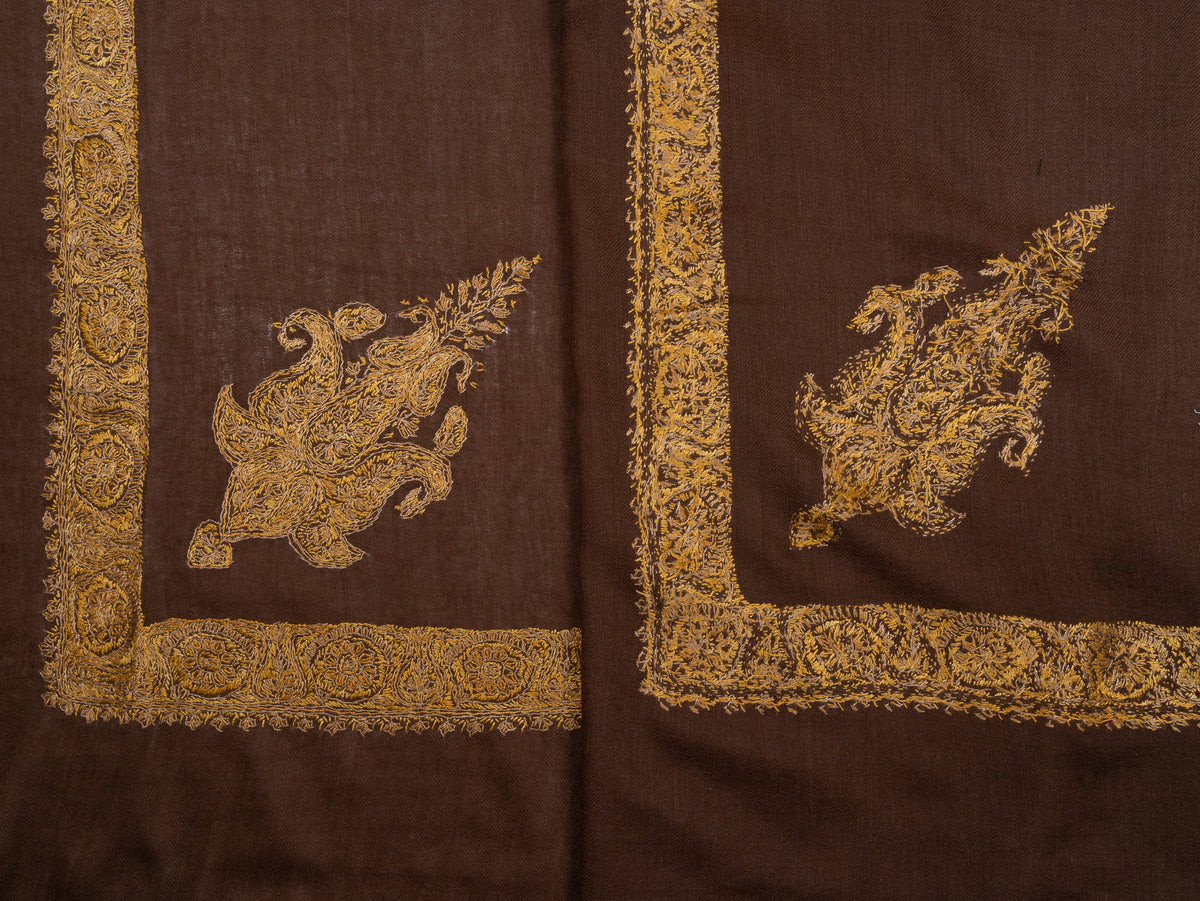Folded umber-brown rumal showing the front and reverse of its golden embroidered borders and paisley corner motifs
