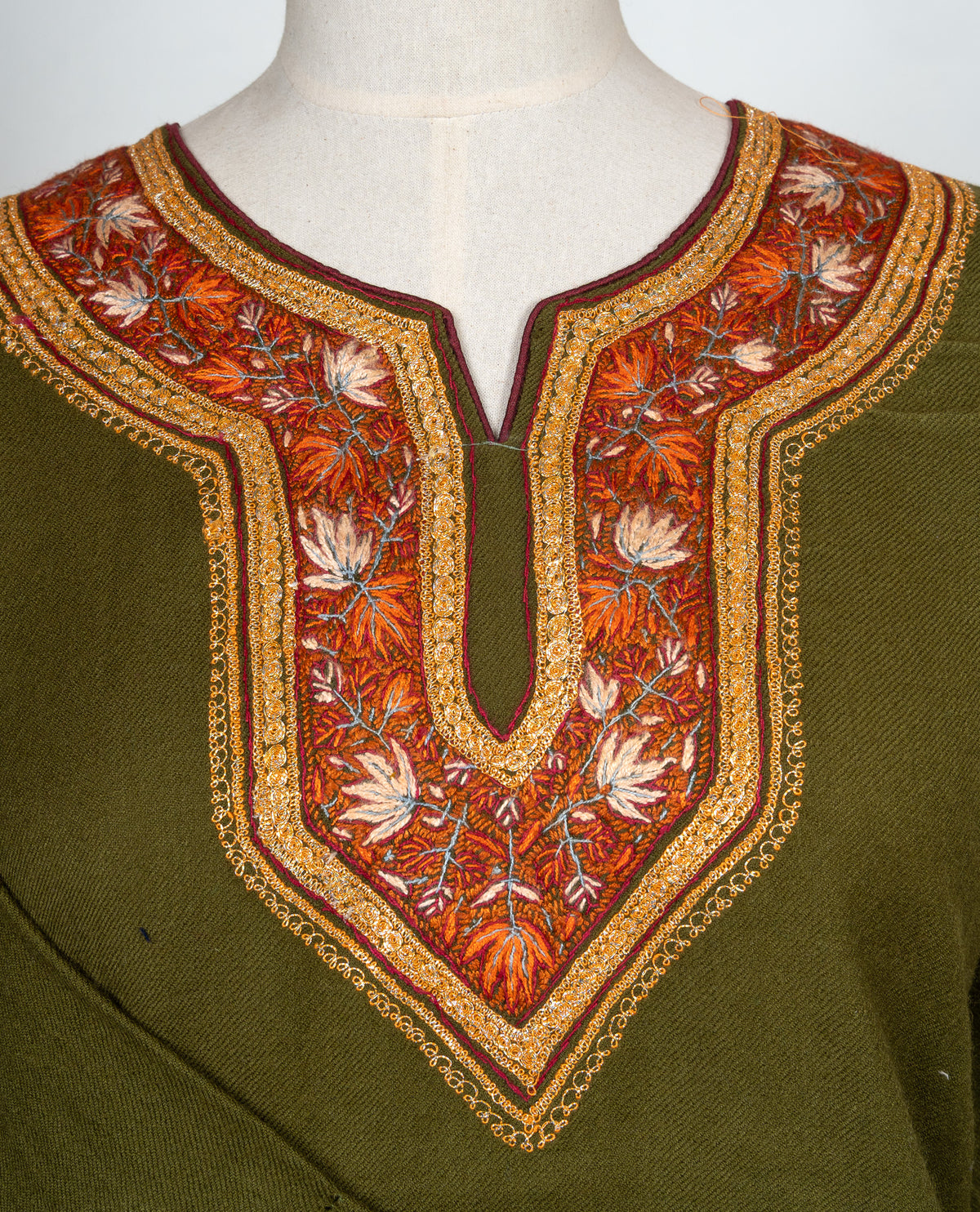 Close-up of orange, ivory and golden Sozni leaves around the notched neckline of an olive-green pheran